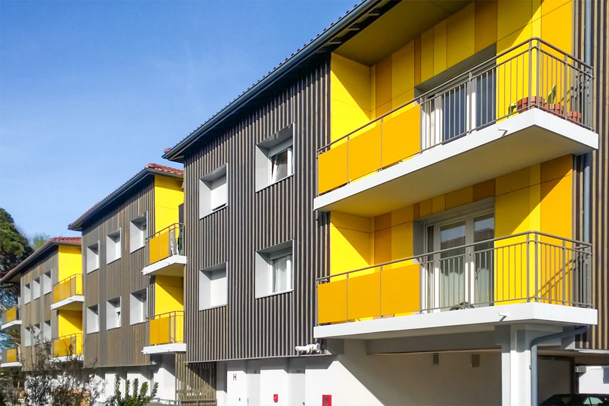 Zoom sur façade aux balcons jaune de la résidence Les Parqueurs réalisé à Gujan-Mestras par l'agence Bulle Architectes.