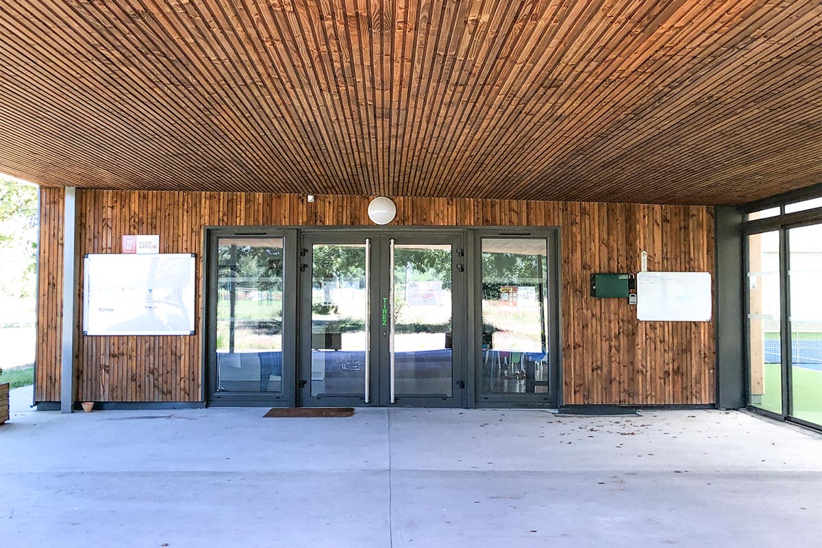 Entrée du club de tennis du Teich réalisé par l'agence Bulle Architectes avec une sous-face en bois.