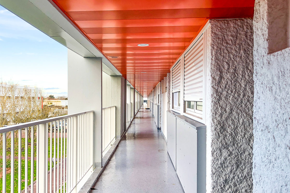 Couloir extérieur menant aux appartements de la résidence Grand Caillou réhabilitée par Bulle Architectes à Bordeaux.