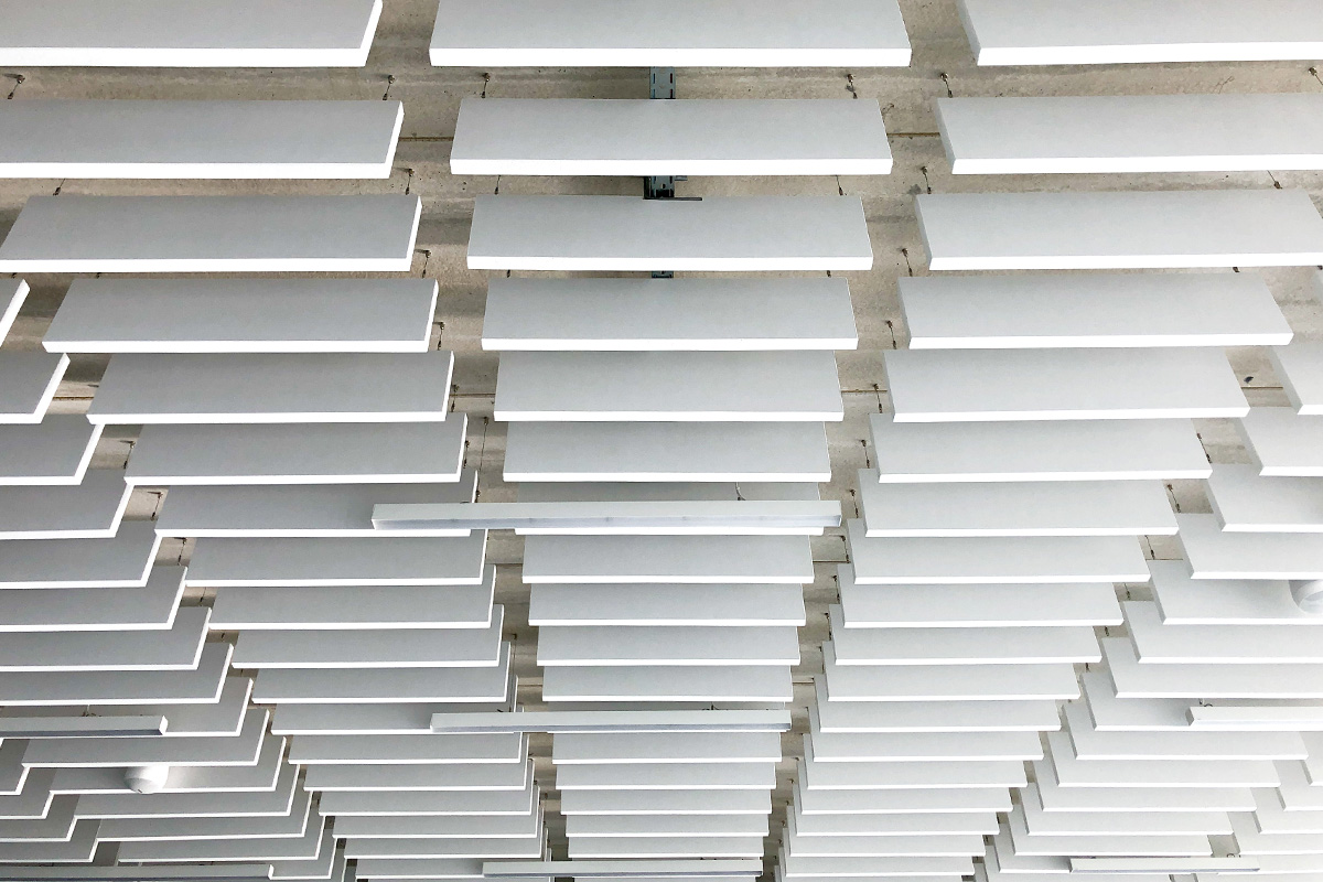 Détail du plafond acoustique blanc de la salle des fêtes de Montpouillan réalisée par l'agence bordelaise Bulle Architectes.